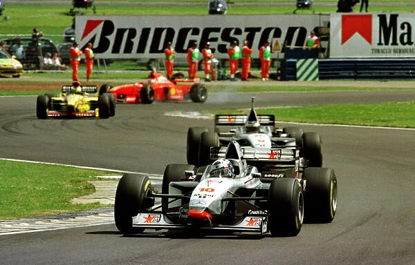 1997 BRITISH GP. David Coulthard leads team mate Mika Hakkinen early on during