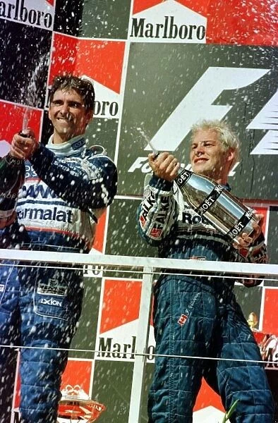1997 HUNGARIAN GP. Jacques Villeneuve and Damon Hill celebrate on the podium after