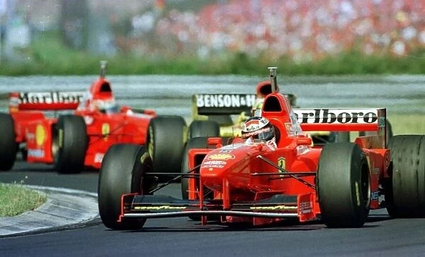 1997 HUNGARIAN GP. Michael Schumacher leads his brother Ralf