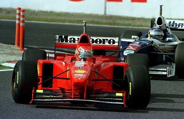 1997 JAPANESE GP. Eddie Irvine holds up Jacques Villleneuve letting Michael Schumacher