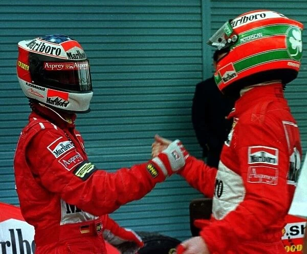 1997 JAPANESE GP. Michael Schumacher celebrates with team mate Eddie Irvine after they both finish on the podium, 1st and 3rd respectively. Photo: LAT
