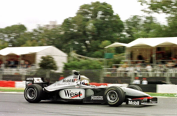 1998 AUSTRALIAN GP. David Coulthard, McLaren Mercedes passes the hospitality tents during Friday practice session. Photo: LAT