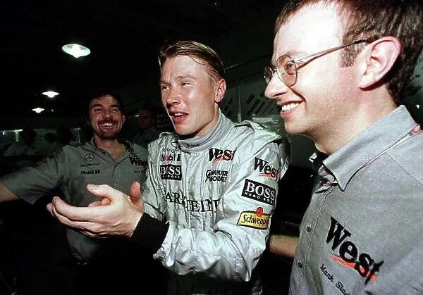 1998 BRAZILIAN GP. Mika Hakkinen, McLaren Mercedes, celebrates with his mechanics after securing his second successive pole position this year. Heading his team mate, David Coulthard into 2nd on the grid for the race in Sau Paulo. Photo: LAT