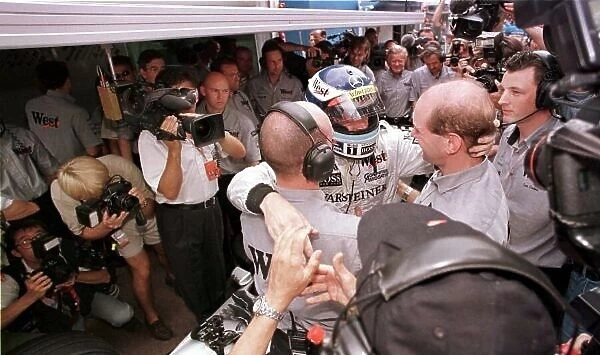 1998 MONACO GP. Mika Hakkinen, McLaren Mercedes, is congratulated by Adrian Newey and his race mechanic as he climbs out of the car after securing another pole position for the race on Sunday. Photo: LAT