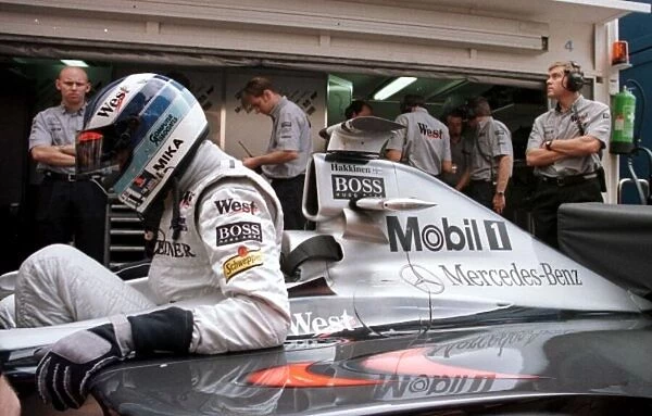 1998 MONACO GP. World Championship leader Mika Hakkinen eases himself into the McLaren