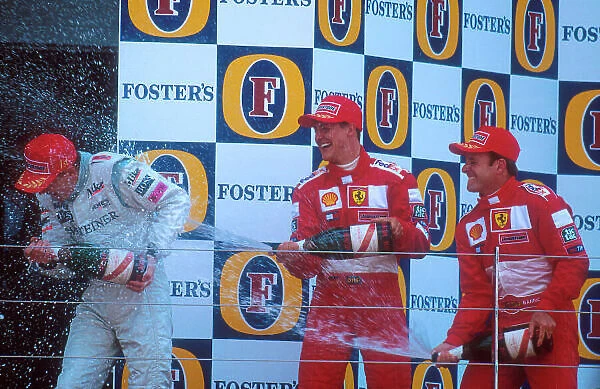 2001 British Grand Prix. Silverstone, England. 13-15 July 2001. Michael Schumacher, 2nd position and Rubens Barrichello 3rd position (both Ferrari) shower Mika Hakkinen (McLaren Mercedes)