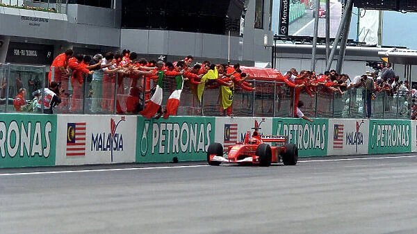 2001 Malaysian Grand Prix Sepang, Kuala Lumpur, Malaysia. 16th - 18th March 2001. Michael Schumacher, Ferrari, makes it 6 wins in a row as he crosses the finish line to the cheers of his team. Race action. World Copyright