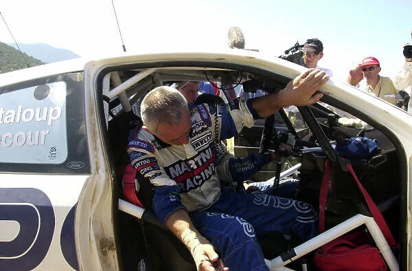 2001 World Rally Championship. Acropolis Rally June 14-17, 2001. Francois Delecour climbs out of the co-drivers seat because of his injured wrist is too painful for him to drive the liaison section to the regroup during leg 2. Photo