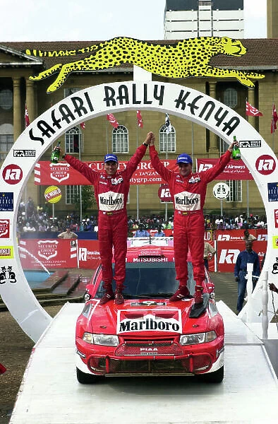 2001 World Rally Championship. Nairobi, Kenya. July 20-22, 2001 Tommi Makinen and Risto Mannisenmaki celebrate their victory on the podium. Photo: Ralph Hardwick / LAT