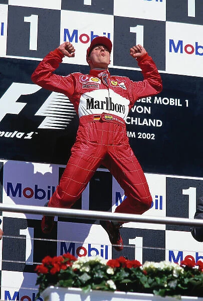 2002 German Grand Prix. Hockenheim, Germany. 26-28 July 2002. Michael Schumacher (Ferrari) does his celebratory trademark jump on the podium for his 1st position. Ref-02 GER 35. World Copyright - LAT Photographic