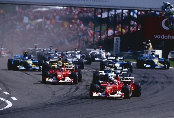 2002 Hungarian Grand Prix: Rubens Barrichello leads team mate Michael Schumacher and Ralf Schumacher into the first corner at the start