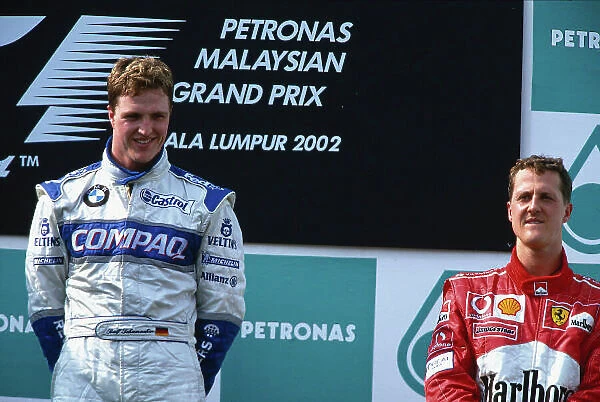 2002 Malaysian Grand Prix Sepang, Malaysia. 15th - 17th March 2002. Race winner Ralf Schumacher, BMW Williams FW24, with brother Michael Schumacher, Ferrari F2001, (3rd) podium.. World Copyright: Steven Tee / LAT Photographic ref: 35mm Image A65