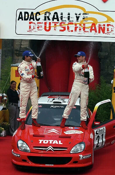 2002 World Rally Championship. ADAC Rallye Deutschland, Trier, August 22-25. Sebastien Loeb and Daniel Elena spray the winners champagne on the podium. Photo: Ralph Hardwick / LAT