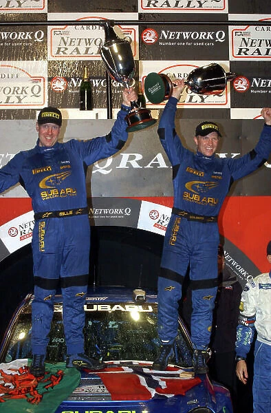 2002 World Rally Championship. Network Q Rally of Great Britain, Cardiff. November 14-17. Petter Solberg (R) and Philip Mills (L) celebrate their first WRC victory on the podium. Photo: Ralph Hardwick / LAT
