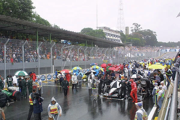 2003 Brazilian Grand Prix - Sunday Race Interlagos, Brazil. 6th April 2003. The rain pours down as the teams are on the grid before the begining of the race. World Copyright LAT Photographic. ref: Digital Image Only
