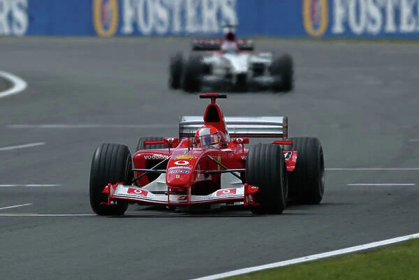2003 British Grand Prix - Sunday race, Silverstone, England. 20th July. Michael Schumacher, Ferrari F2003 GA, leads Jenson Button, B•A•R Honda 005, action. World Copyright LAT Photographic. Digital Image Only