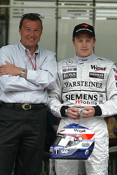 2003 Spanish Grand Prix - Sunday Race, Barcelona, Spain. 4th May 2003. Kimi Raikkonen, Team McLaren Mercedes MP4 / 17D, is presented with the new TAG Heuer link watch to commemorate his first Formula One win in the 2003 Malaysian Grand Prix by