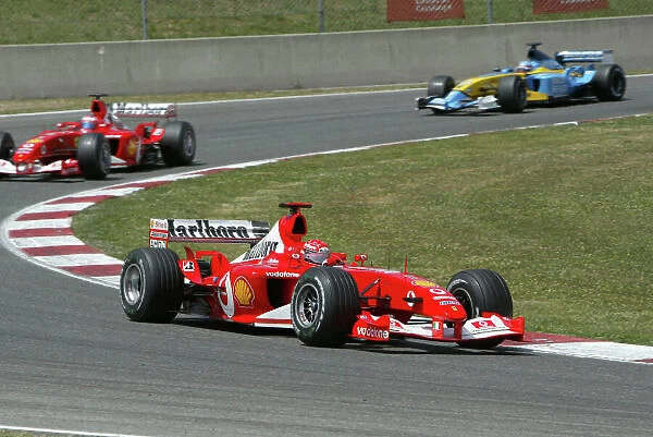 2003 Spanish Grand Prix - Sunday Race, Barcelona, Spain. 4th May 2003. Michael Schumacher, Ferrari F2003 GA, leads Rubens Barrichello, Ferrari F2003 GA, and Fernando Alonso, Renault R23, action. World Copyright LAT Photographic