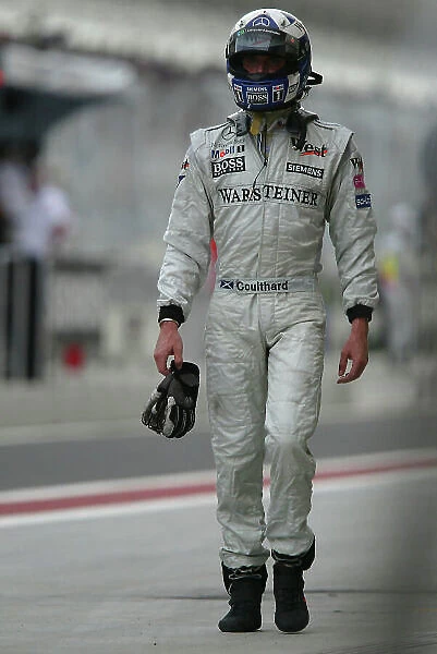 2004 Bahrain Grand Prix - Sunday race, Sakhir, Bahrain. 4th April 2004 David Coulthard, McLaren Mercedes MP4-19, walks back to the pit garage after his car stopped at the end of the pit lane. World Copyright LAT Photographic. Digital image only