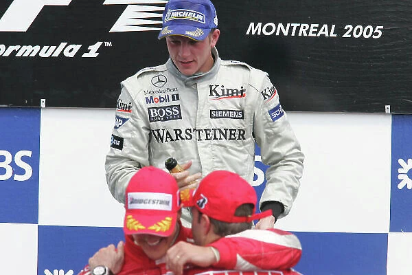 2005 Canadian Grand Prix - Sunday Race, Montreal, Canada. 12th June 2005 Race podium - winner Kimi Raikkonen, McLaren Mercedes MP4-20 (1st) looks on as Michael Schumacher, Ferrari F2005 (2nd) and team mate Rubens Barrichello