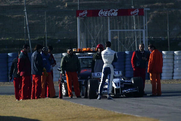 2005 Formula One Testing Jerez, Spain. 11th January 2005 Mark Webber waits with marshalls and his broken down WilliamsF1 BMW FW26. World Copyright: Malcolm Griffiths / LAT Photographic ref: Digital Image Only
