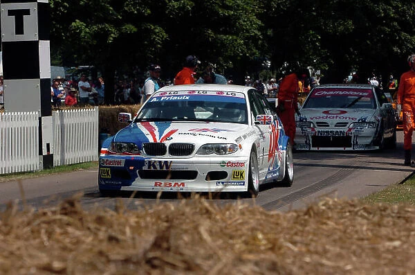 2005 Goodwood Festival of Speed Goodwood Estate, West Sussex. 24th - 26th June. Andy Priaulx's WTCC BMW 320i heads away from the start as the BTCC Nissan Primera prepares. Action