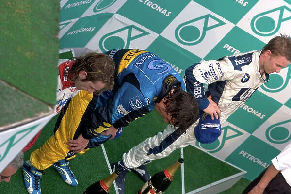 2005 Malaysian Grand Prix - Sunday Race, Sepang, Kuala Lumpur, Malaysia. 20th March 2005 Fernando Alonso, Renault R25 on the podium unable to stand after his drink bottle ceased to work