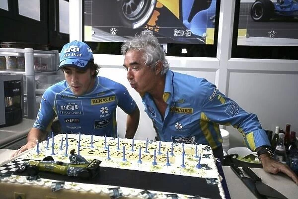 2006 German Grand Prix - Saturday Qualifying Hockenheim, Germany. 27th - 30th July. Fernando Alonso, Renault R26, celebrates his birthday with a cake and is helped with the candles by Flavio Briatore