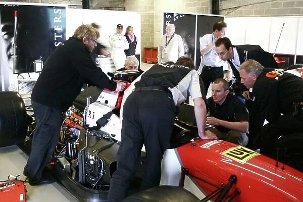 2006 Grand Prix Masters. Silverstone, England. 11th - 13th August. Mechanics struggle to fix the car of Nigel Mansell to get him out of the garage and into qaulifying. Action