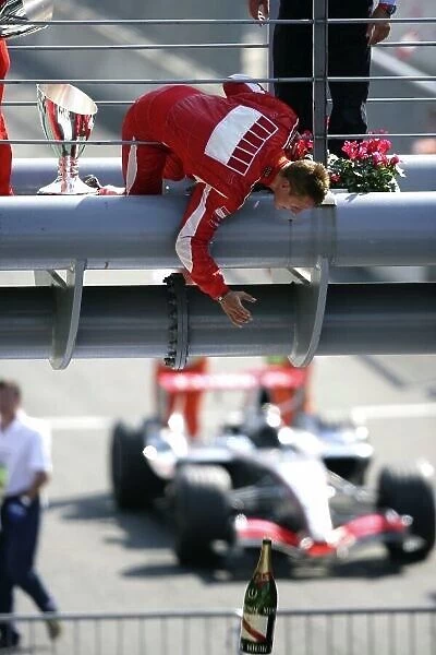 2006 Italian Grand Prix - Sunday Race Autodromo Nazionale Monza, Italy. 7th - 10th September 2006. Michael Schumacher, Ferrari 248F1, 1st position, celebrates on the podium, bt dropping the winners champagne botttle to his engineers