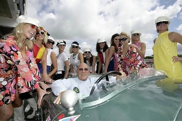 2007 Goodwood Revival Press Day. Goodwood, West Sussex. 18th July 2007. Sir Stirling Moss, C Type Jaguar, with The Essolube Girls. World Copyright: Gary Hawkins / LAT Photographic. Ref: Digital Image Only