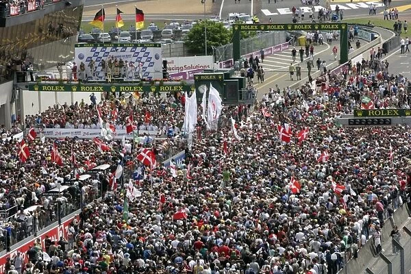 2010 Le Mans 24 Hours: A huge crowd forms beneath the podium to celebrate a clean sweep for Audi with Mike Rockenfeller  /  Timo Bernhard  /  Romain Dumas