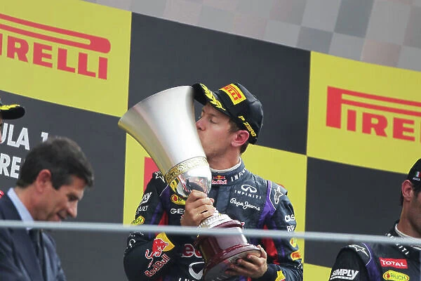 Autodromo Nazionale di Monza, Monza, Italy. 8th September 2013. Sebastian Vettel, Red Bull Racing, 1st position, kisses the winners trophy on the podium. World Copyright: Andy Hone / LAT Photographic. ref: Digital Image HONY8293