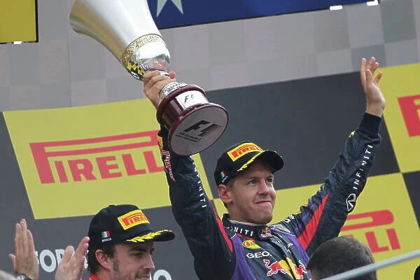 Autodromo Nazionale di Monza, Monza, Italy. 8th September 2013. Sebastian Vettel, Red Bull Racing, 1st position, lifts his trophy on the podium. World Copyright: Andy Hone / LAT Photographic. ref: Digital Image HONY8287