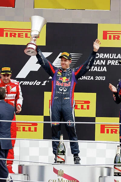 Autodromo Nazionale di Monza, Monza, Italy. 8th September 2013. Sebastian Vettel, Red Bull Racing, 1st position, lifts his trophy on the podium. World Copyright: Charles Coates / LAT Photographic. ref: Digital Image _N7T5654