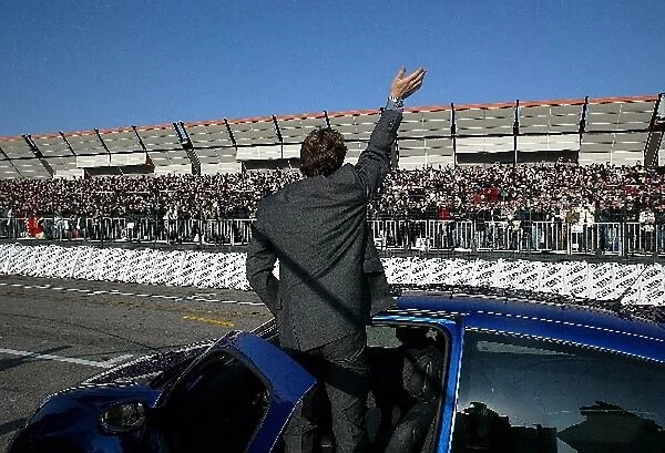 Bologna Motor Show: Jarno Trulli demonstrates a Renault Clio and waves to the crowd