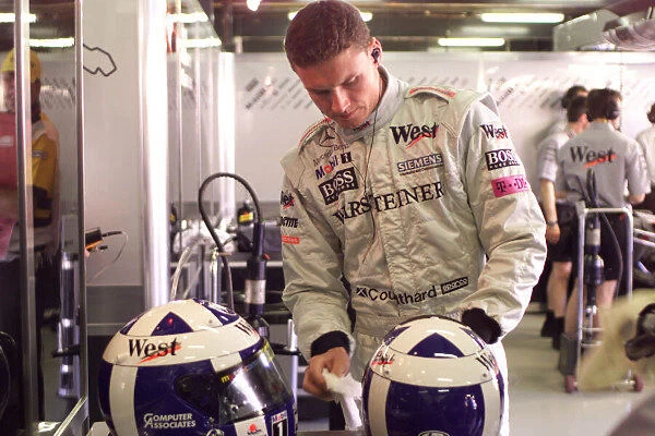 David Coulthard cleans the visor on his helmet