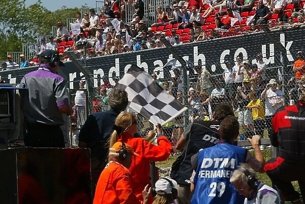 DTM: Damon Hill BRDC Chairman waves the chequered flag at the end of the race
