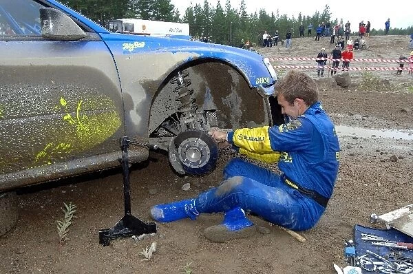 FIA World Rally Championship: Chris Atkinson makes some repairs to his Subaru after clipping a rock on stage 4