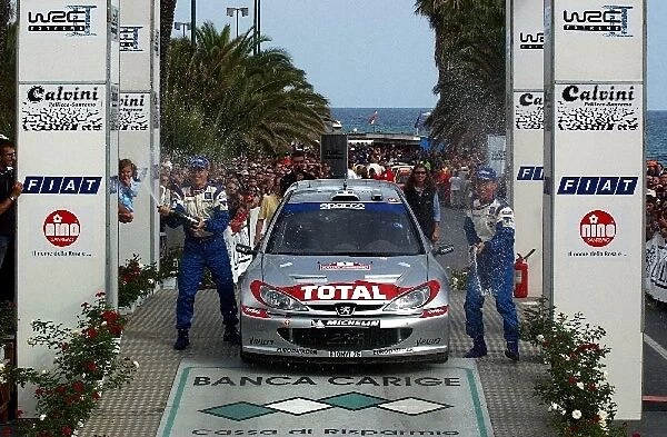 FIA World Rally Championship: Herve Panizzi, left, and Gilles Panizzi, right, Peugeot 206 WRC, celebrate victory with champagne on the podium