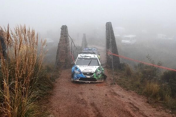 FIA World Rally Championship: Matthew Wilson, Ford Focus WRC, limps across a bridge on stage 20 after knocking a wheel off; closely followed