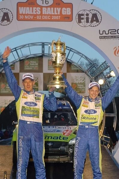 FIA World Rally Championship: Mikko Hirvonen Ford Focus WRC, and his co-driver Jarmo Lehtinen celebrate victory on the podium in Cardiff