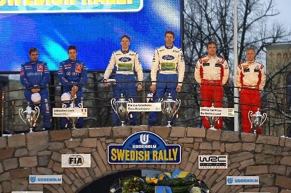 FIA World Rally Championship: The podium: Sebastien Loeb with co-driver Daniel Elena Kronos Total Citroen Xsara WRC second; Marcus Gronholm with