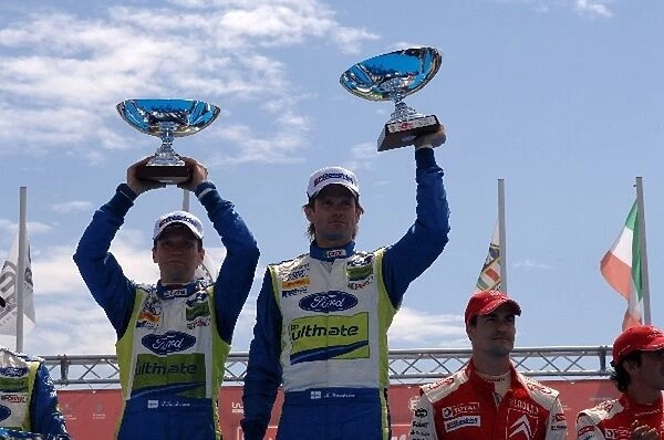 FIA World Rally Championship: Rally winners L-Timo Rautiainen and R-Marcus Gronholm, Ford, with the winners trophies on the podium in Porto Cervo