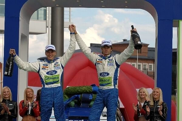 FIA World Rally Championship: Winners Marcus Gronholm and Timo Rautiainen celebrate victory with the Ford team on the podium