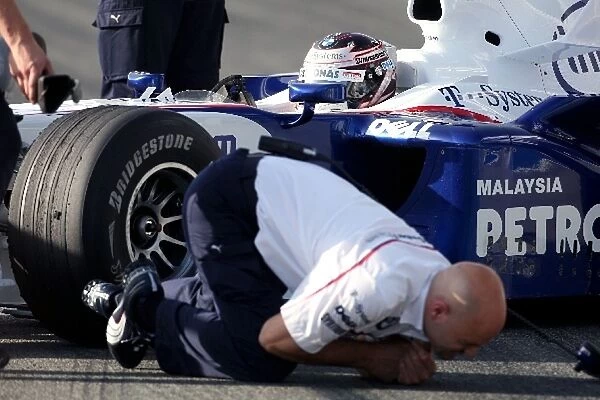 Formula One Testing: A BMW Sauber mechanic receives an electric shock from Christian Klien BMW F1.08 running a KERS system