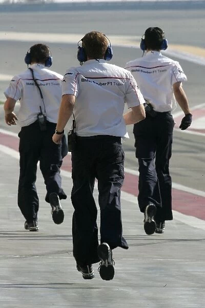 Formula One Testing: BMW Sauber mechanics run up the pit lane to push Nick Heidfeld BMW Sauber F1. 07 back to his pit garage