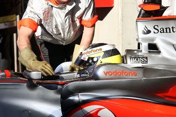 Formula One Testing: McLaren mechanics use rubber gloves to touch the KERS enabled car of Pedro De La Rosa McLaren Test Driver