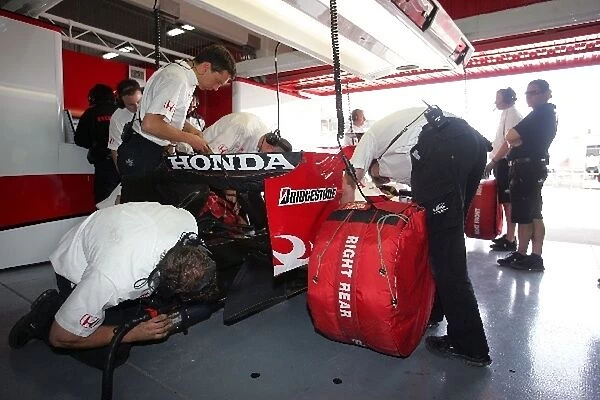 Formula One Testing: Mechanics start the car of Takuma Sato Super Aguri F1 Team SA07 in the garage