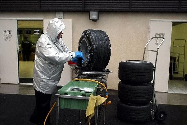 Formula One Testing: A Michelin tyre technician washes the wheels